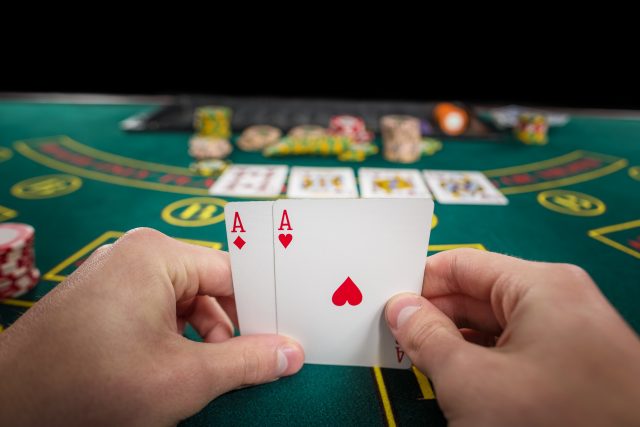 male poker player holding two cards aces Almanbahis Adres